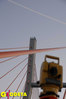 Ilustracja: <b class=pic_title>W ruch idą tachimetry, na wierzchołku pylonu nadal pracuje GPS, a nad nim leci samolot, godzina 6.20</b> <br />
<br />
<b class=pic_author>fot.  Jerzy Przywara</b><br />
<br />
